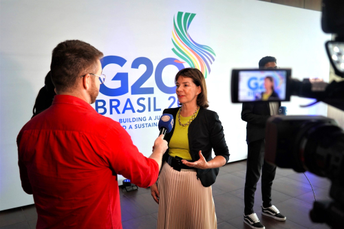 Julia standing at G20 Brazil logo