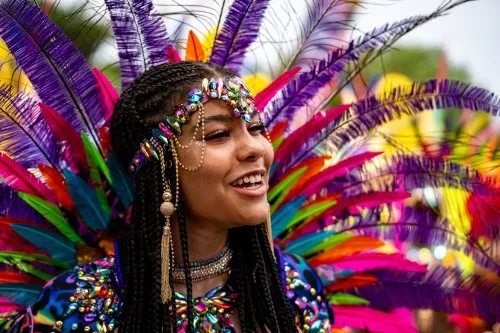 Lady dressed up in a colourful outfit for a festival - listing tile
