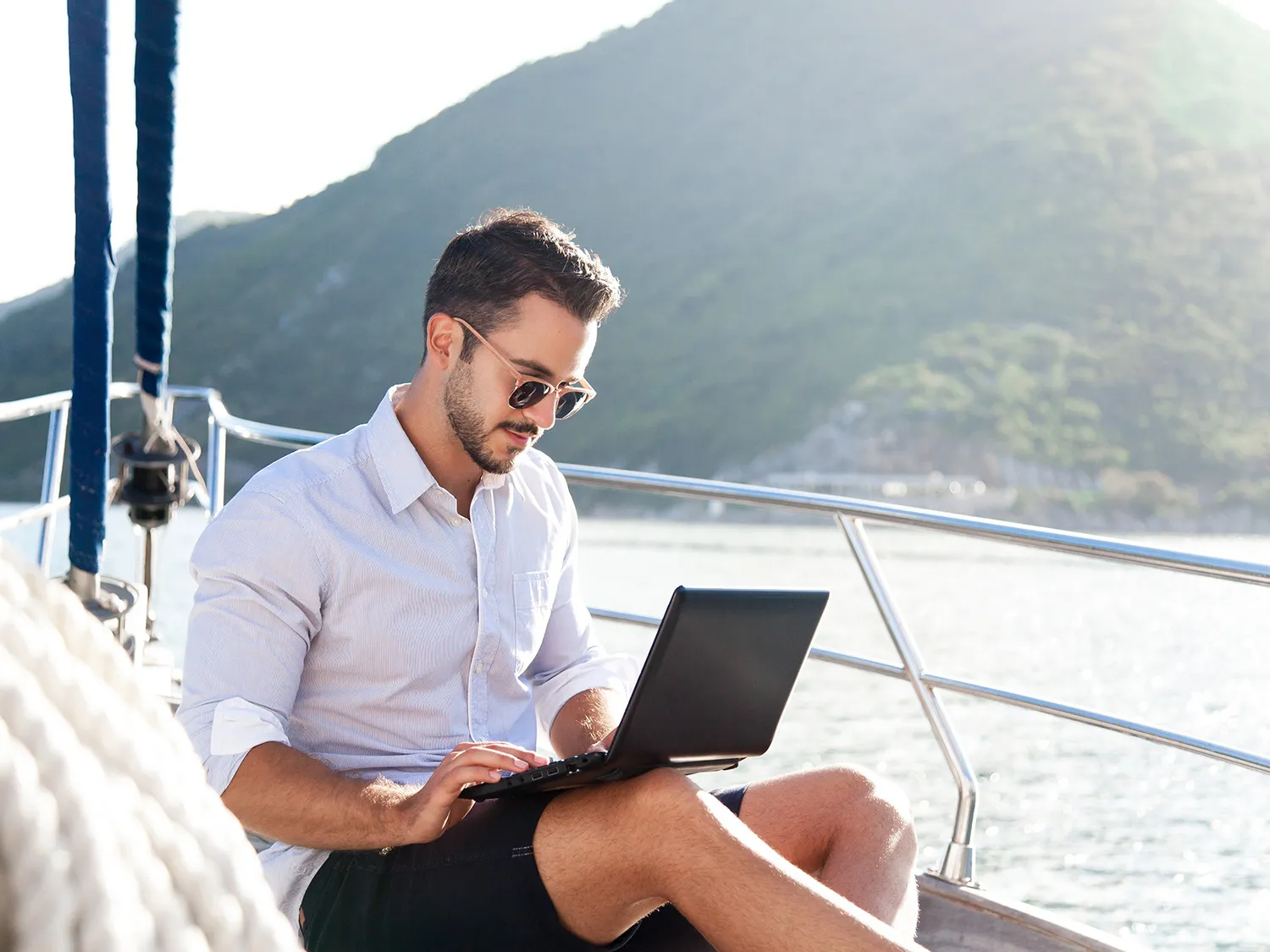 man on a boat working at his laptop 